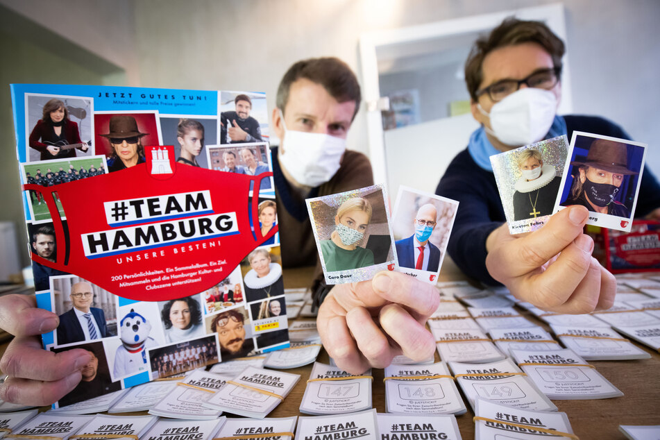 Alexander Böker (l) und Oliver Wurm halten das von ihnen herausgegebene Panini-Sammelalbum in die Kamera.