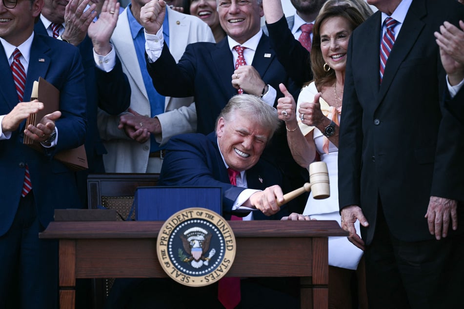 US President Donald Trump (c.) bangs a gavel after signing the "Big Beautiful Bill Act" at the White House in Washington, DC, on Friday.
