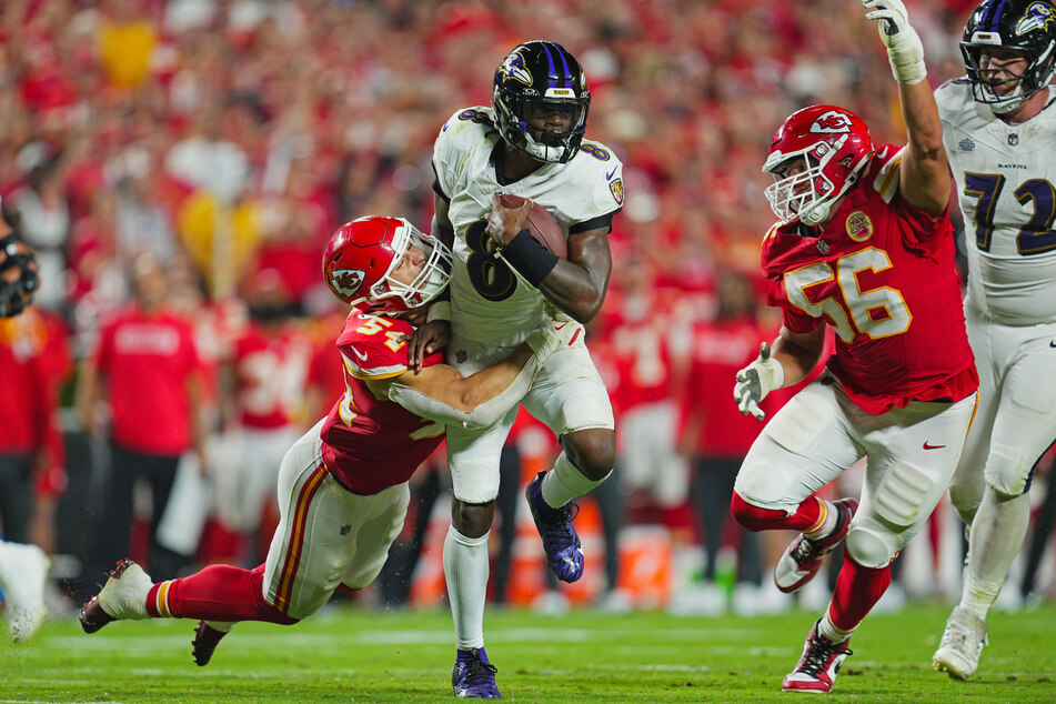 Baltimore Ravens quarterback Lamar Jackson runs the ball against Kansas City Chiefs linebacker Leo Chenal and defensive end George Karlaftis during the second half.