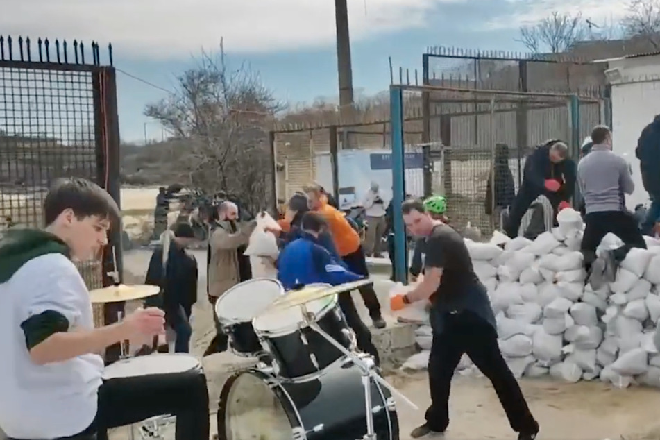 Locals in Odesa rock out to the Bon Jovi anthem while filling sandbags on a beach.