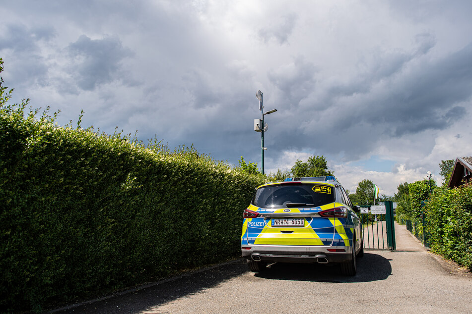 Ein Polizeiauto steht vor der Gartenanlage, in der der vermutliche Haupttäter Teile seiner Server-Anlage in einer Gartenlaube unterbrachte.