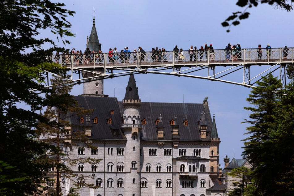 Touristen stehen auf der Marienbrücke vor dem Schloss Neuschwanstein. In der Nähe der Touristen-Attraktion soll die schreckliche Gewalttat stattgefunden haben.