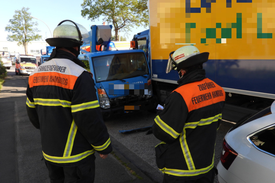 Feuerwehrleute stehen an der Unfallstelle.