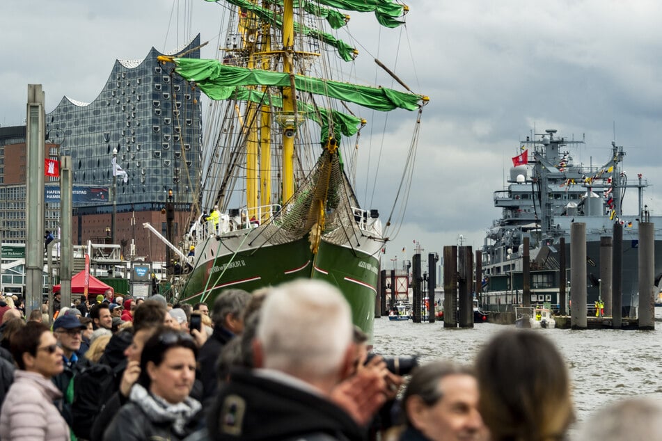 Besucher des Hafengeburtstags betrachten die an den Landungsbrücken ankernden Schiffe, darunter die Alexander von Humboldt II.