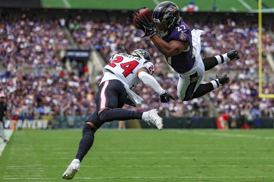 J.K. Dobbins of the Baltimore Ravens dives into the end zone past Derek Stingley Jr. of the Houston Texans for a touchdown in the first quarter at M&amp;T Bank Stadium.