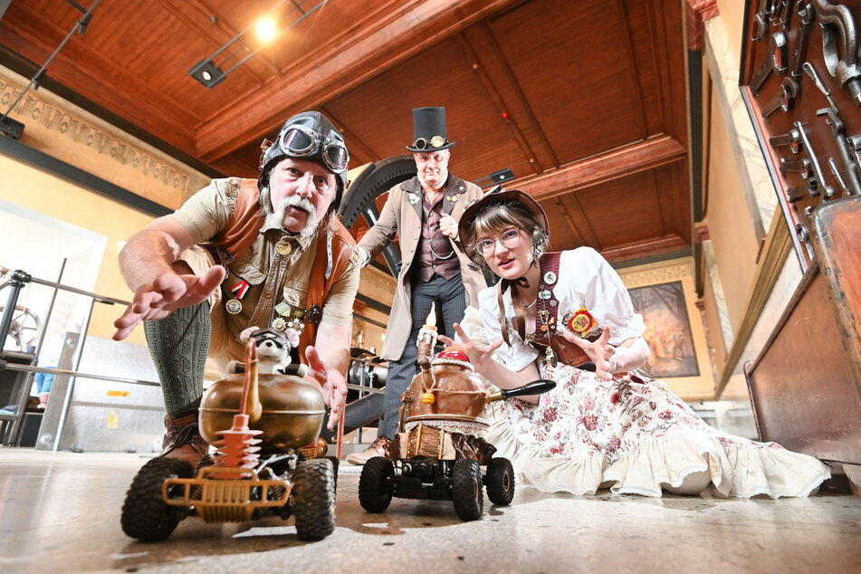 Holger Keil (64, l.) und Nele Hausch (19) schicken unter den Augen von Jens Mahlow (60) beim Steampunk-Festival ihre selbstgebauten Teekannen auf Rädern ins Rennen.