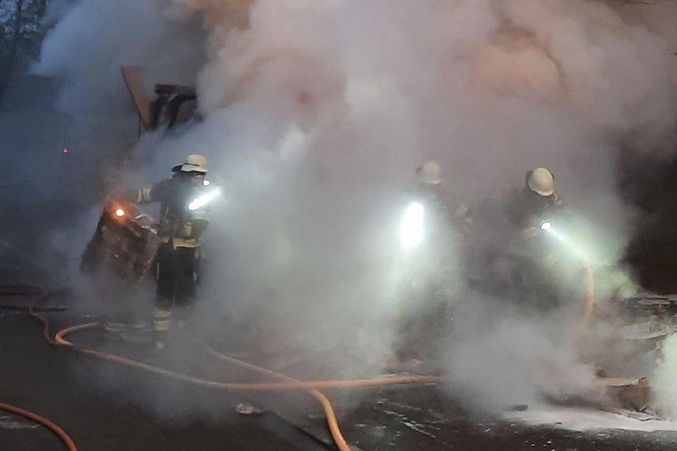 Die Einsatzkräfte der Münchner Berufsfeuerwehr stehen im dichten Rauch.