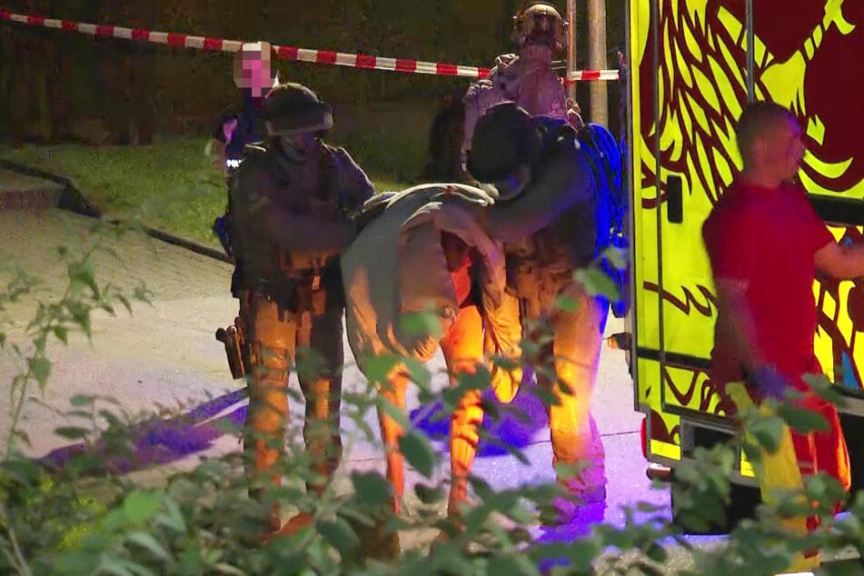 Kräfte des Sondereinsatzkommandos führten den 46-Jährigen (M.) mit einer Decke über dem Kopf ab.