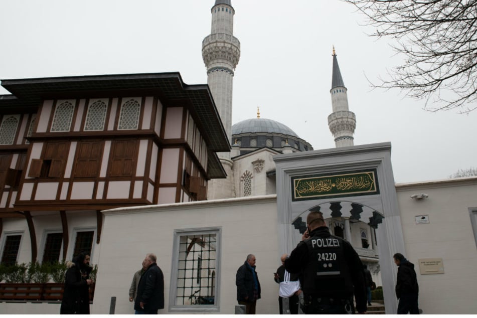 Ein Polizist steht vor einer Neuköllner Moschee. (Symbolbild/Archivbild)