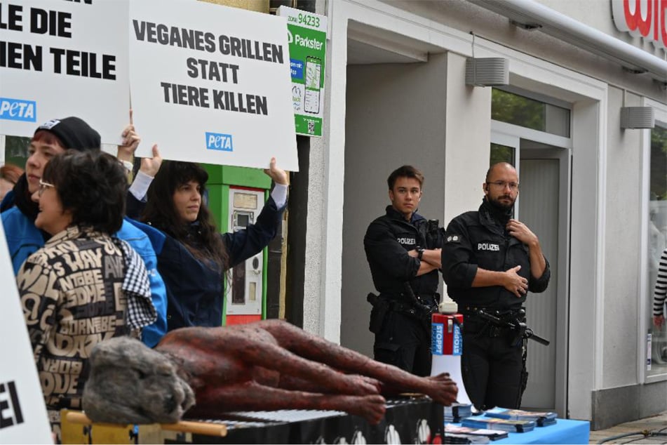 Aktivisten haben eine Hundeattrappe auf einen Grill gelegt. Die Polizei hat den Protest im Blick.
