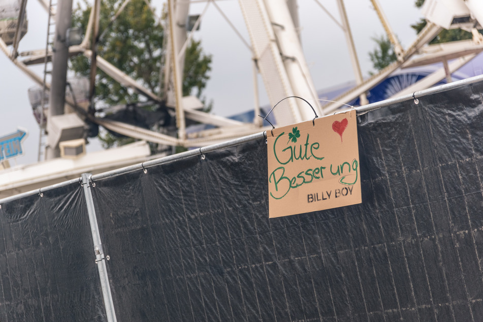 Festivalgänger hatten am Sonntag ein Schild am Riesenrad angebracht, um den Betroffenen eine schnelle Genesung zu wünschen. 16 Menschen mussten nach dem Brand ins Krankenhaus gebracht werden. Schwerverletzte oder Personen mit lebensgefährlichen Verletzungen gab es glücklicherweise nicht.