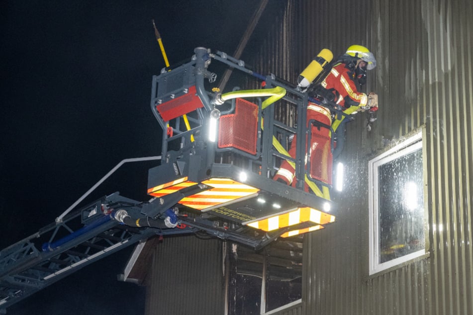 Mithilfe einer Drehleiter wurden Teile der Seitenverkleidung des Gebäudes geöffnet, um Glutnester im Dachgeschoss zu löschen.