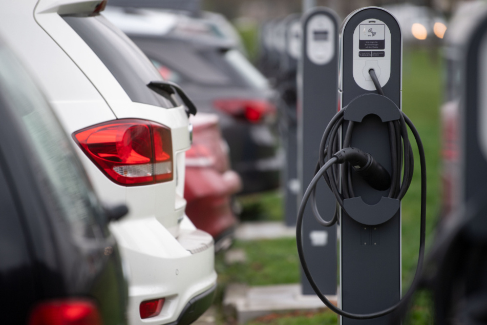 Elektrofahrzeug-Ladestationen stehen auf einem Parkplatz vor einem Gelände, auf dem eine Batteriefabrik der Daimler AG entstehen soll.