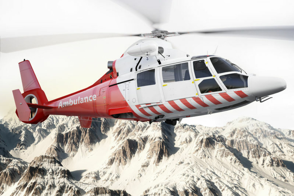 Ein Rettungshubschrauber fliegt über schneebedeckte Berge (Symbolfoto).