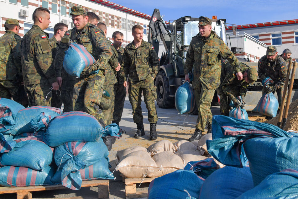 Soldaten der Bundeswehr verladen Sandsäcke bei einer Katastrophenschutzübung. (Symbolbild)