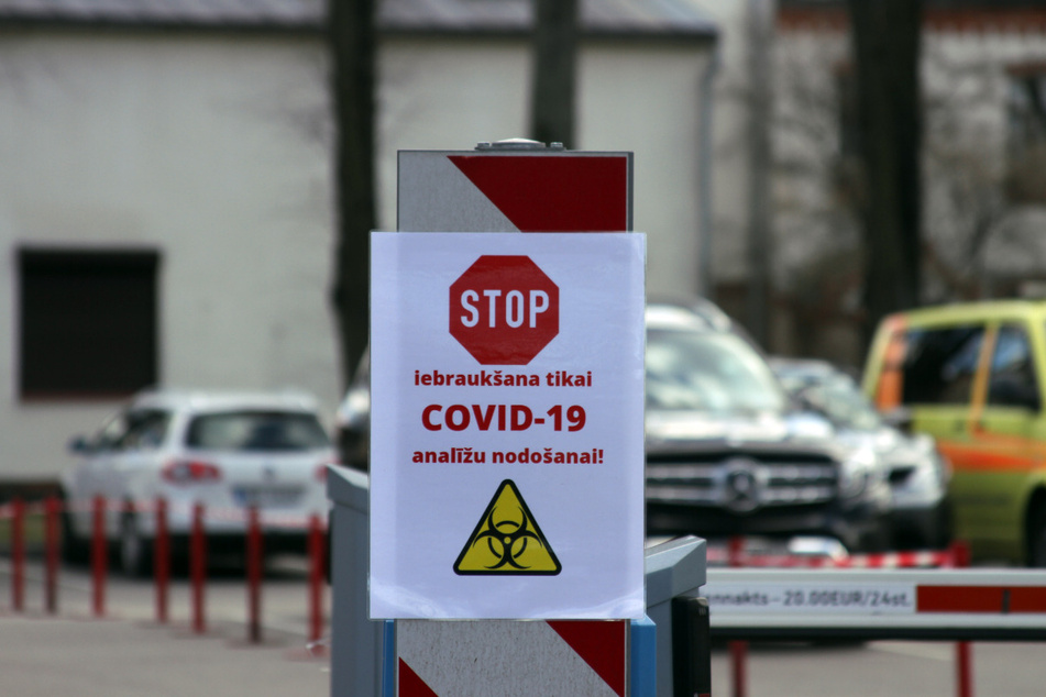 Ein Schild mit einem Stoppzeichen und der Aufschrift "Iebrauksana tikai Covid-19 Analizu nodosanai" (Einfahrt nur zur Abgabe von Covid-19 Analyse) hängt an einer Schrankenanlagen an der Einfahrt zur Teststation an der Pauls-Stradins-Universitätsklinik in Riga.