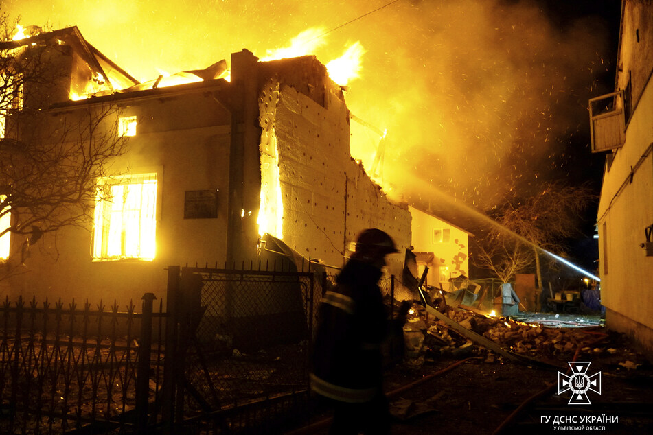 Feuerwehrleute bei den Löscharbeiten an einem brennenden Gebäude in Dubljany nach einem russischen Drohnenangriff.