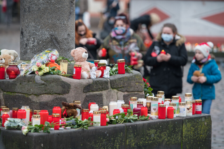 An mehreren Stellen in der Fußgängerzone, hier am Marktkreuz, haben Menschen zum Gedenken an die Opfer der Amokfahrt Kerzen aufgestellt.