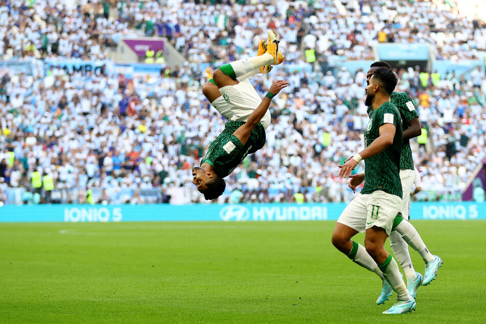 Salem Al-Dawsari (c.) does a backflip after scoring Saudi Arabia's winning goal against Argentina.