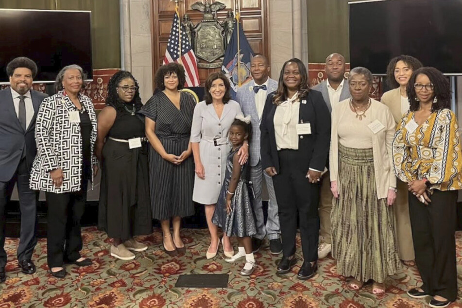 New York lawmakers and reparations commissioners pose for a photo during the nine-member body's first official meeting in Albany.