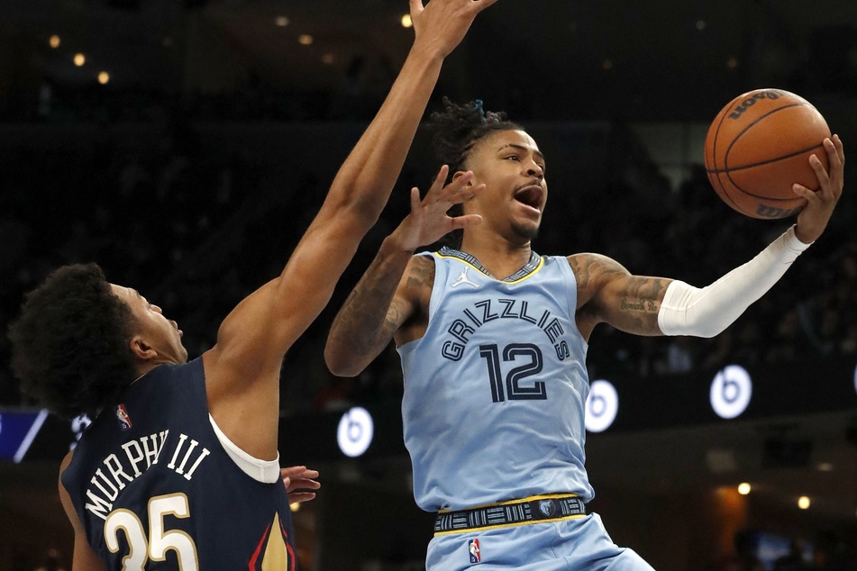 After missing nine game with a sore knee, Ja Morant (r) returned to the Grizzlies to score 21 points against the Pelicans.