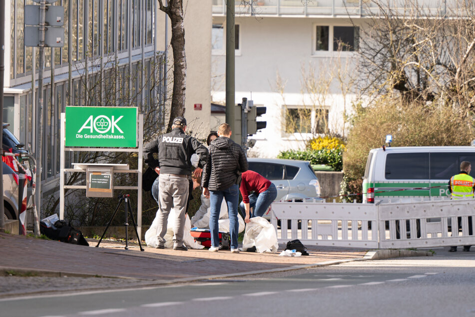 Einsatzkräfte der Polizei stehen am Fundort der Leiche nahe der AOK-Zentrale in Freising.