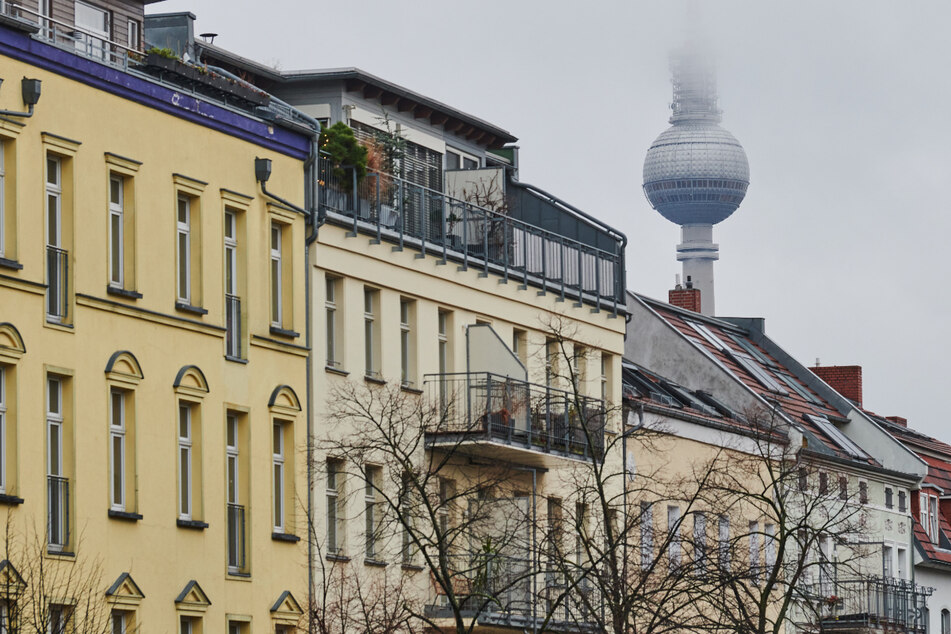 Der Fernsehturm verschwindet hinter einer Häuserreihe im Stadtteil Prenzlauer Berg im Nebel.
