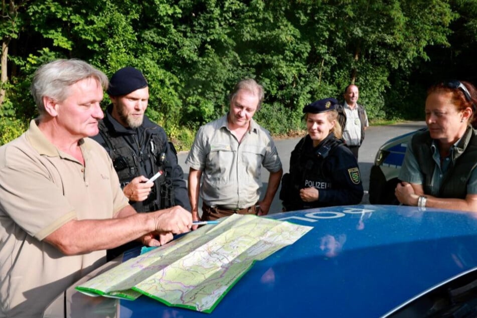 Lagebesprechung vor dem Einsatz: Das Team bespricht mit Blick auf die Karte, wo gezielt nach Boofern Ausschau gehalten wird.