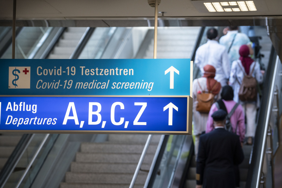 Ein Schild weist im Ankunftsbereich des Frankfurter Flughafens den Weg zu den Abflügen und den Covid-19-Testzentren.