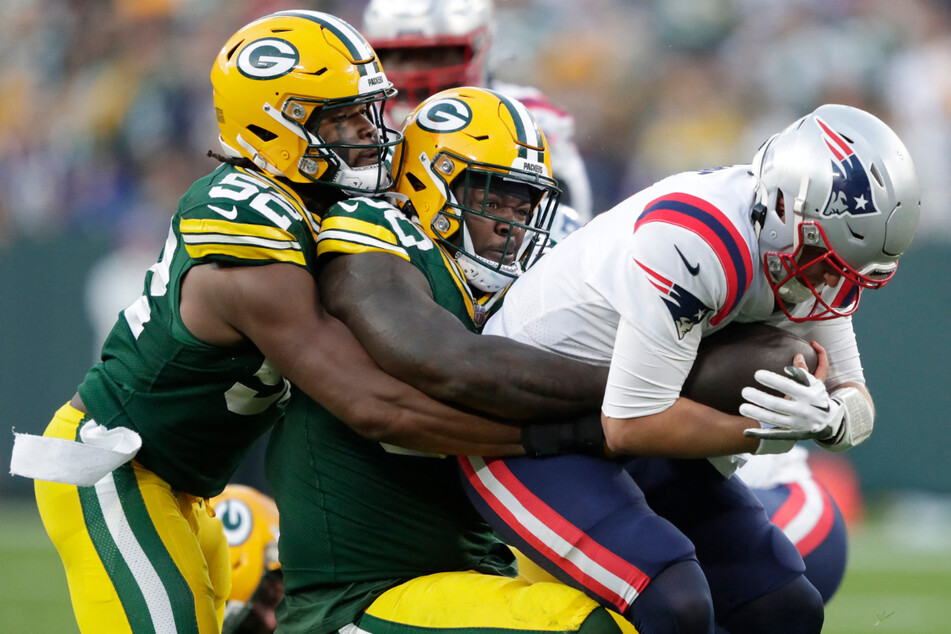 New England Patriots quarterback Bailey Zappe (r.) was sacked by Green Bay Packers defensive tackle Jarran Reed (c.) as linebacker Rashan Gary (l.) helped on the play during their game on Sunday at Lambeau Field.