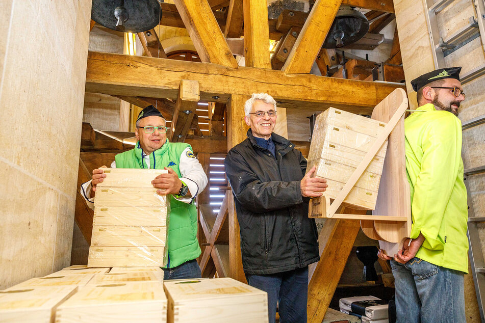 Bäcker Rüdiger Zopp (58, v.l.n.r.) und Pfarrer Markus Engelhardt (60) nehmen Bäcker André Faustmann (40) im Glockenturm die Stollen ab.
