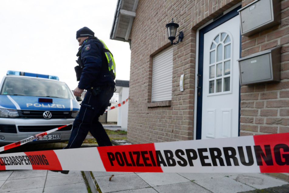 Ein Polizist verlässt ein Haus. (Symbolbild)
