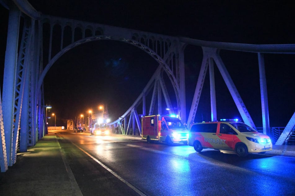 Rettungswagen stehen mit eingeschaltetem Blaulicht auf der Glienicker Brücke, unter der am Sonntagabend eine 59-Jährige hilflos in der eiskalten Havel trieb.