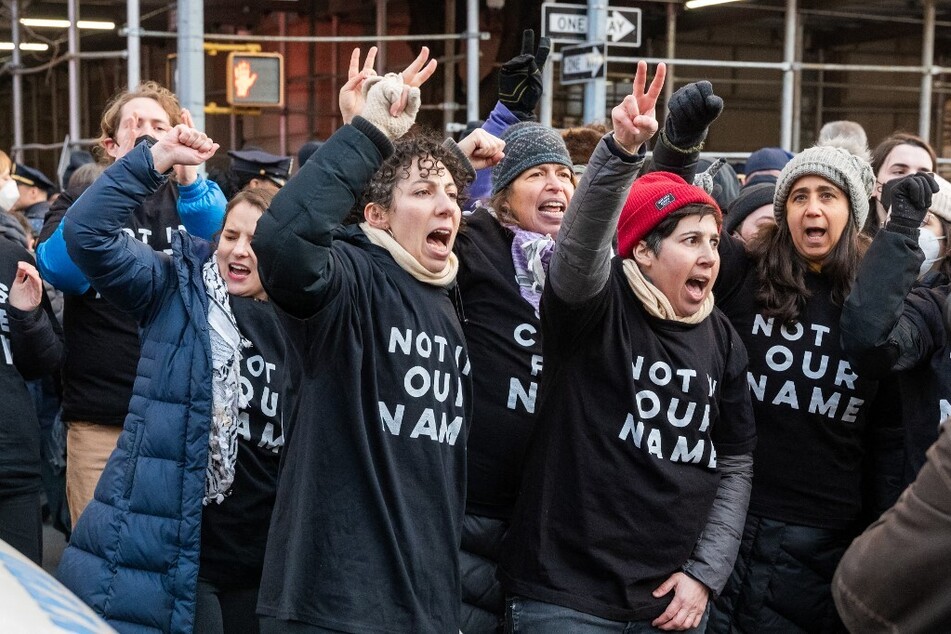 Members of Jewish Voice for Peace wear shirts reading "Not In Our Name" as they protest Israel's US-backed assault on the people of Palestine.