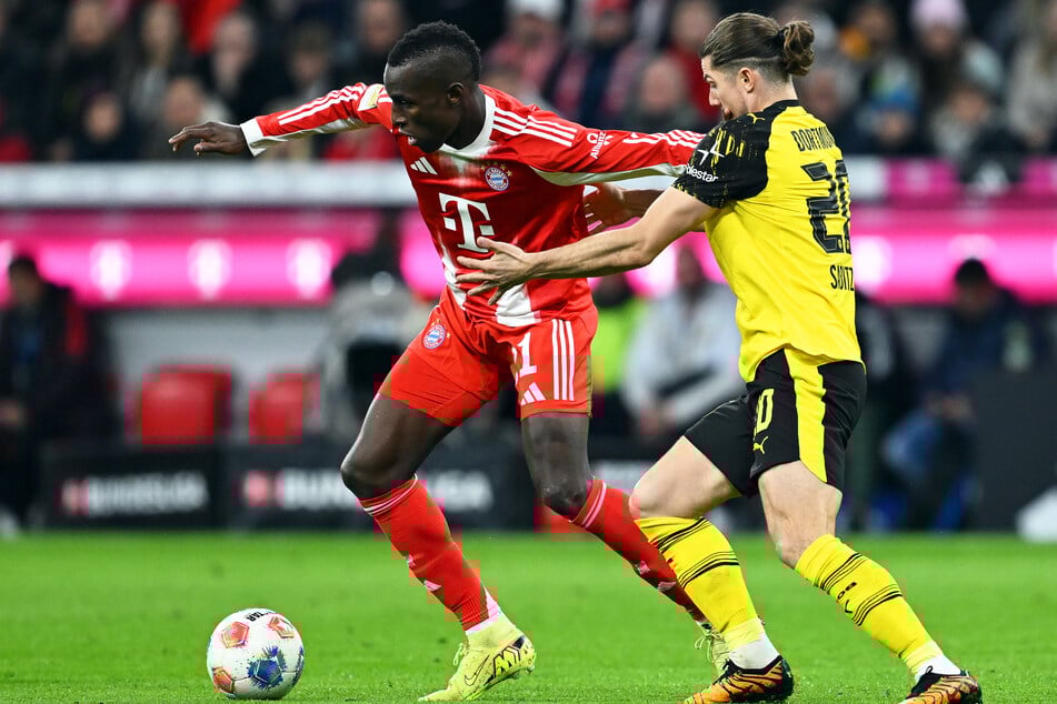 Nicolas Jackson (l, Bayern München) und Marcel Sabitzer (Borussia Dortmund) kämpfen um den Ball.