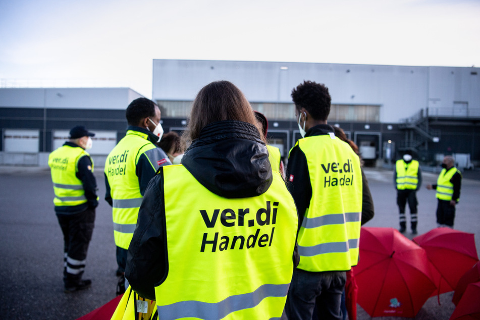 Mitarbeiter aus dem Einzelhandel stehen bei einem Warnstreik mit Warnwesten. Wegen einer ergebnislosen ersten Tarifrunde sind für Freitag in Thüringen, Sachsen und Sachsen-Anhalt im Einzelhandel Streiks angekündigt. (Archivbild)