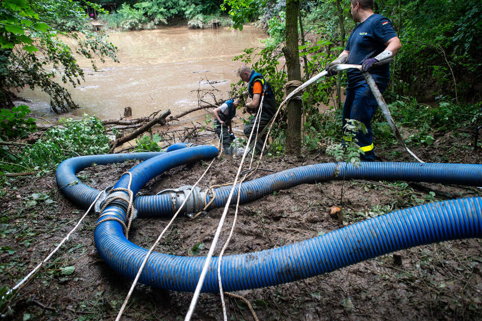 Mitarbeiter des Technischen Hilfswerks (THW) legten am Montag am Deich, der zu brechen drohte, Schläuche und pumpten das Wasser ab.