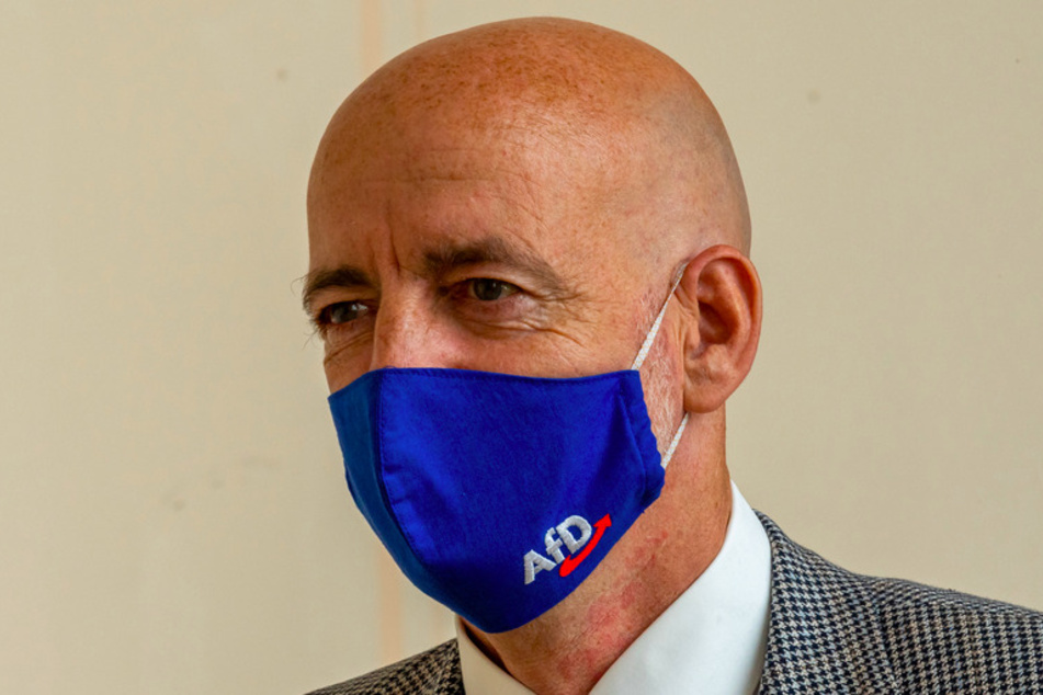 Martin Böhm, Abgeordneter der AfD, geht, vor Beginn der Plenarsitzung des bayerischen Landtags mit einer Mundschutzmaske mit AfD-Logo, durch die Gänge des Gebäudes.