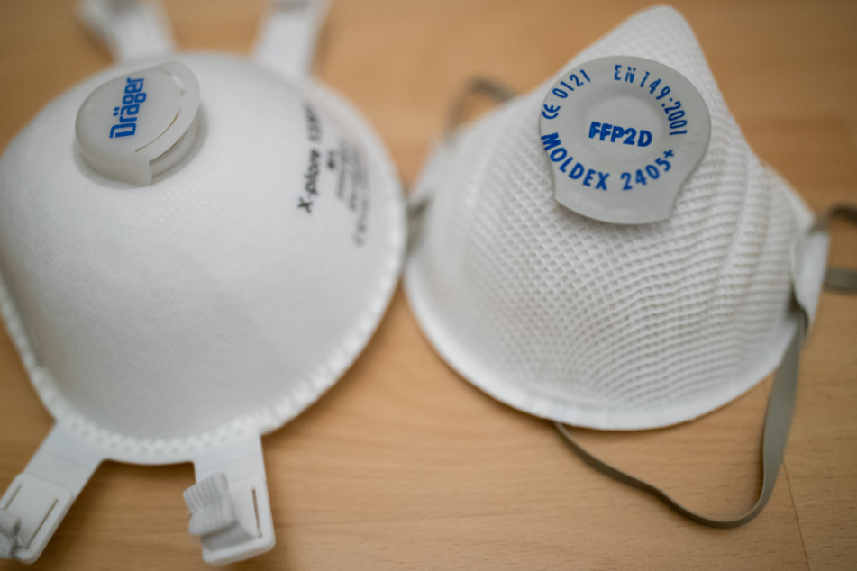 Atemschutzmasken (partikelfiltrierende Halbmasken) der Schutzklasse FFP2 (r) und FFP3 liegen auf einem Tisch.
