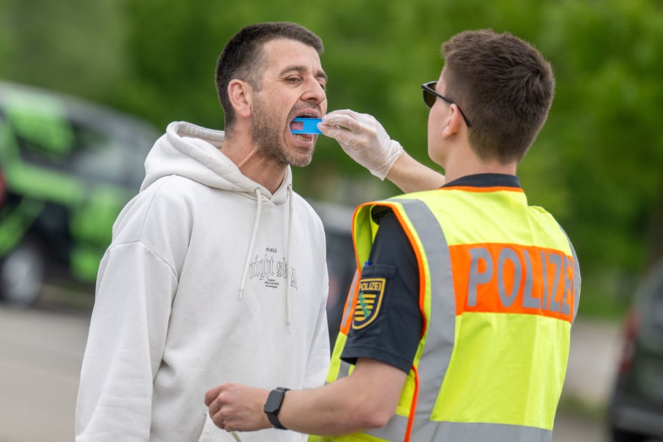 Ein Beamter führt einen Drogenschnelltest bei einem Verkehrsteilnehmer durch.