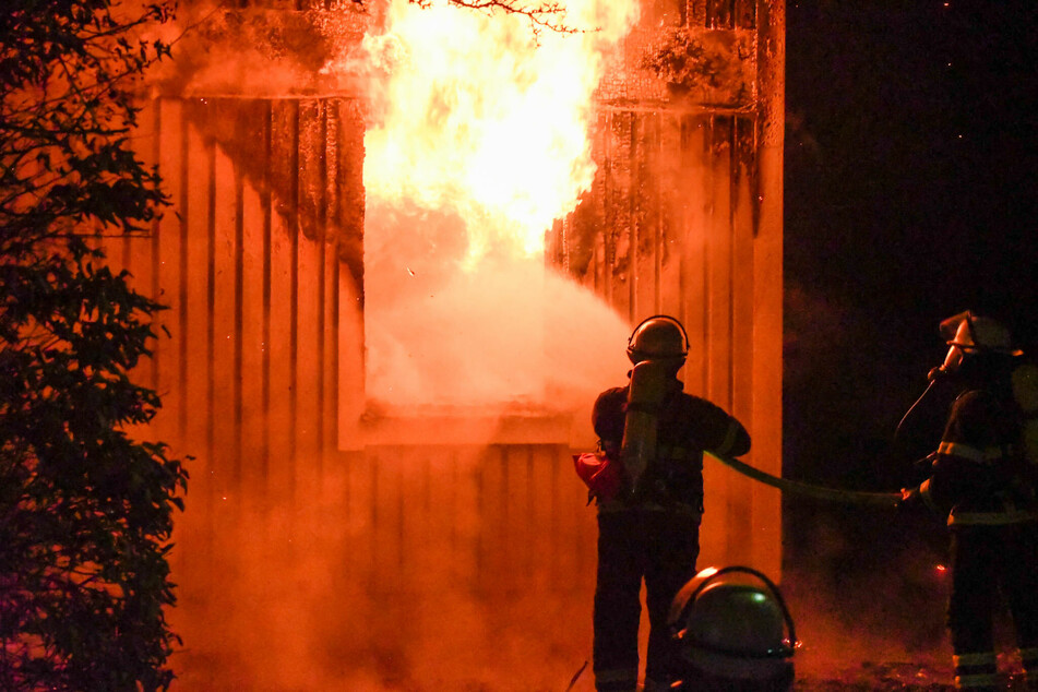 Feuerwehrleute kämpfen gegen die Flammen in dem Gebäude.