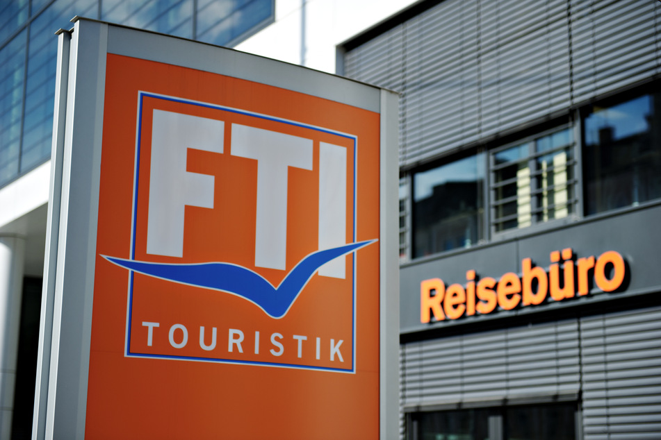 Das Logo des Reiseveranstalters FTI-Touristik vor einem Reisebüro.