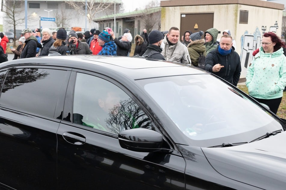 Michael Kretschmer (46, CDU) verlässt in seinem Dienstwagen vor Demonstranten das Gewerbegebiet Bischofswerda.^