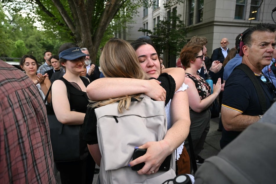 Fired US State Department workers embrace as they leave the building in Washington, DC, on Friday.