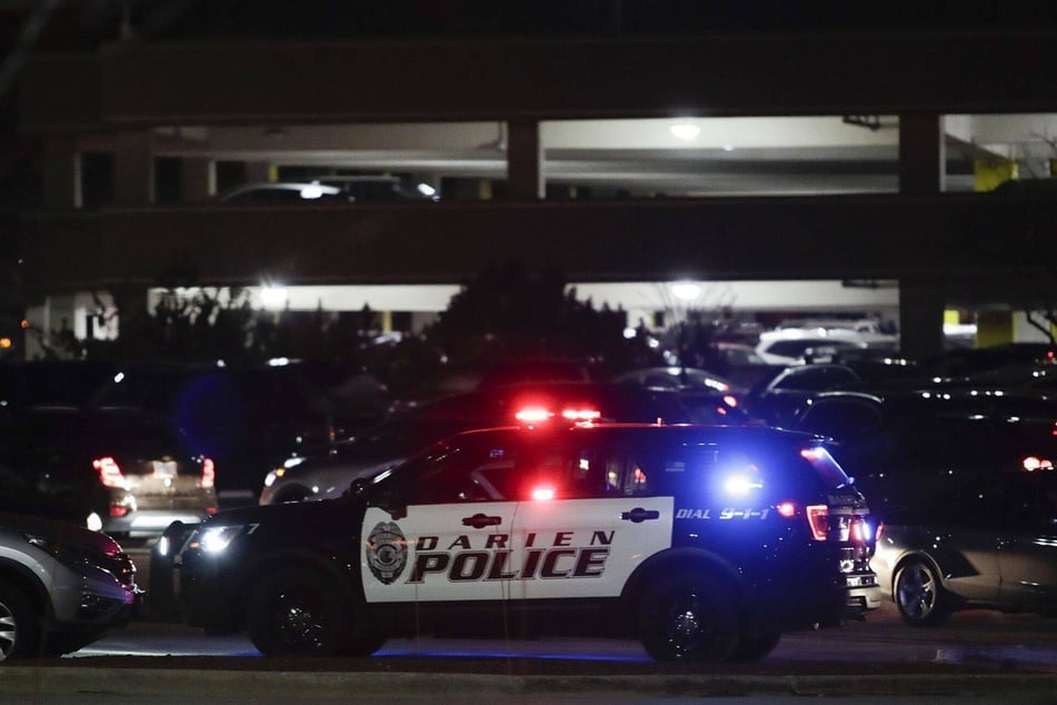 A police car arrives on the scene after a reported shooting at the Oakbrook Center shopping mall.