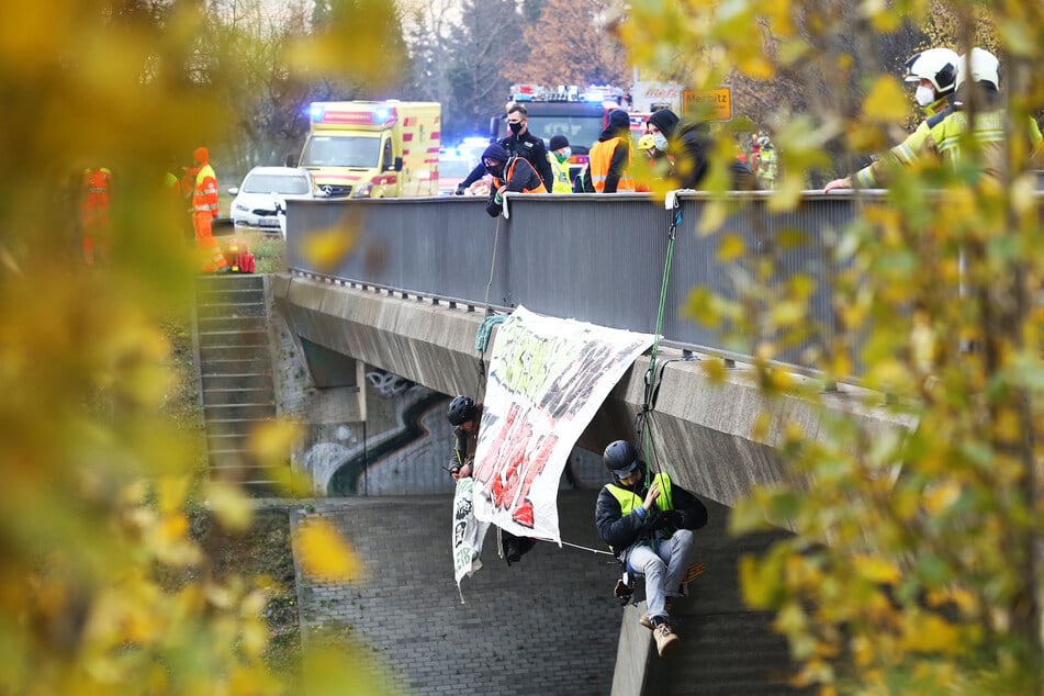 Zwei Aktivisten hängen neben ihrem Banner über der A4-Fahrbahn.