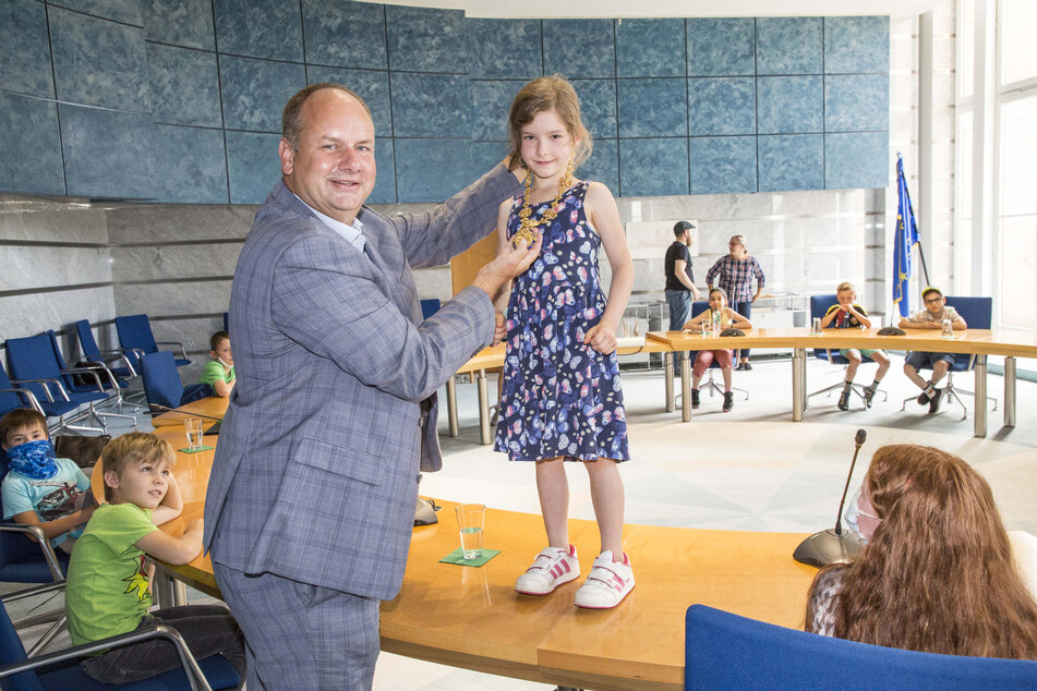 Alma (7) darf die Amtskette von Oberbürgermeister Dirk Hilbert (48, FDP) anprobieren.
