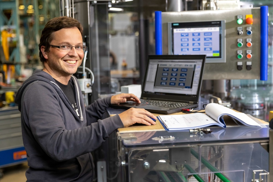 Elektrokonstrukteur Herr Weißflog (38) programmiert eine Maschine für die Fertigung.