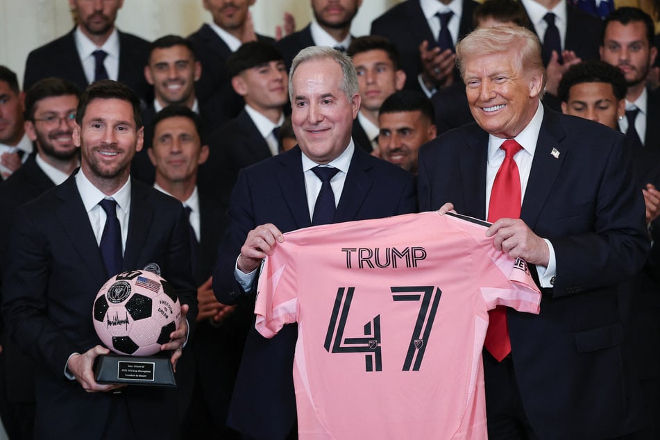 President Donald Trump (r.) receives gifts from Inter Miami CF CEO and Managing Owner Jorge Mas (c.) as Lionel Messi (l.) looks on during an event celebrating the 2025 MLS Cup Champions at the White House on March 5, 2026.