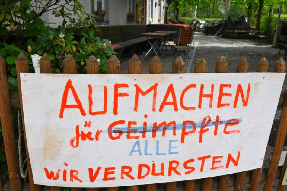 Ein Banner mit der Forderung, die Biergärten wieder zu öffnen, hängt am Zaun eines Biergartens in München.